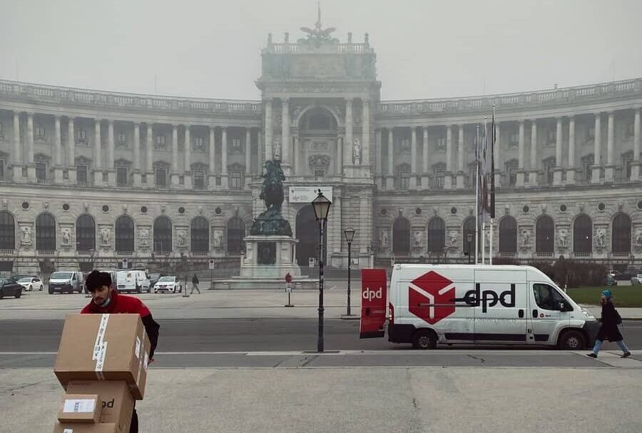 white and red cars parked near white concrete building during daytime