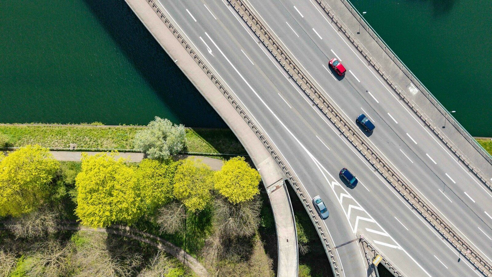 Photo by Bernd 📷 Dittrich Cars driving on a highway overpass near green trees