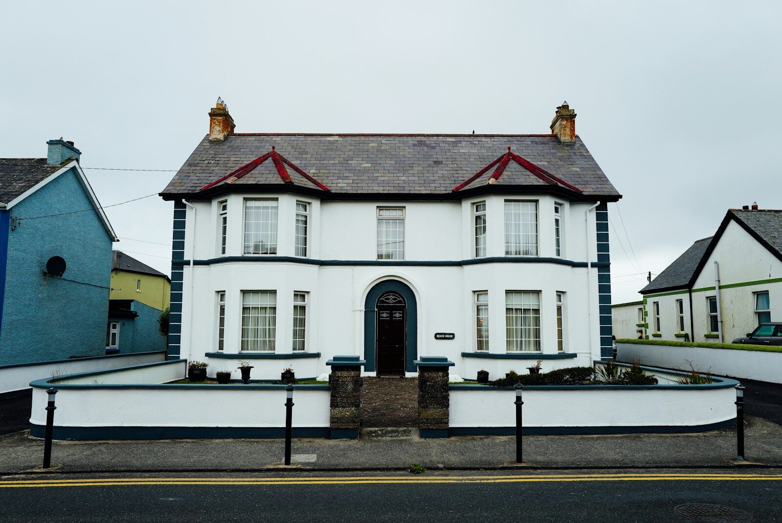A white two-story house with a dark roof.