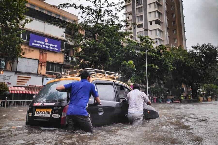 man in gray jacket and gray pants standing beside black car during daytime
