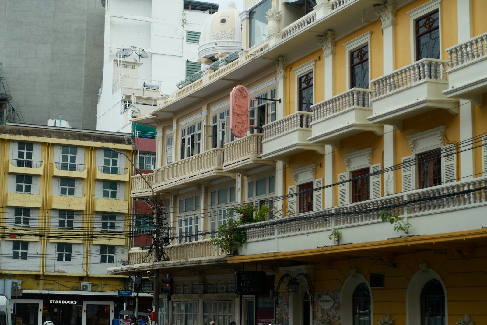 Yellow building with balconies and windows.